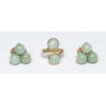 A jade green cabochon set twist ring, cross over crest of two jade green round cabochons, tapering