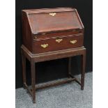 An '18th century' oak bureau on stand, fall front enclosing a stepped arrangement of small