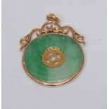 A jade disc pendant, flat jade multi-tone ring with central pierced window, collar surround with