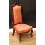 A Victorian mahogany nursing chair, shaped cresting rail pierced and carved with acanthus, stuffed