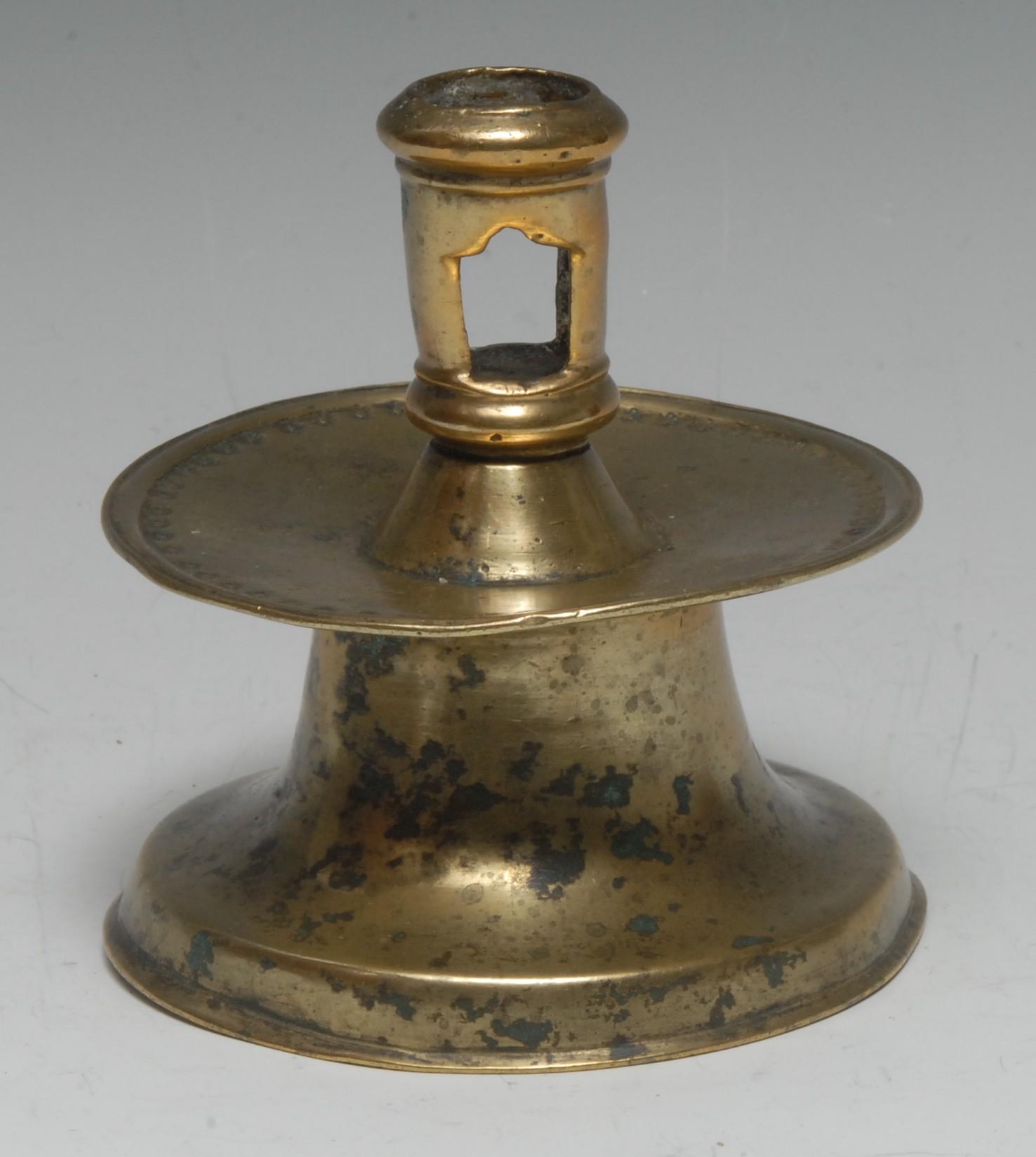 A 16th century Spanish brass capstan candlestick, pierced cylindrical sconce, broad slightly