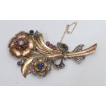 A mid 20th century multi stone diamond, ruby and sapphire floral brooch, multi layered body as a