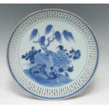 A Chinese circular dish, painted in tones of underglaze blue with chrysanthemums, prunus and