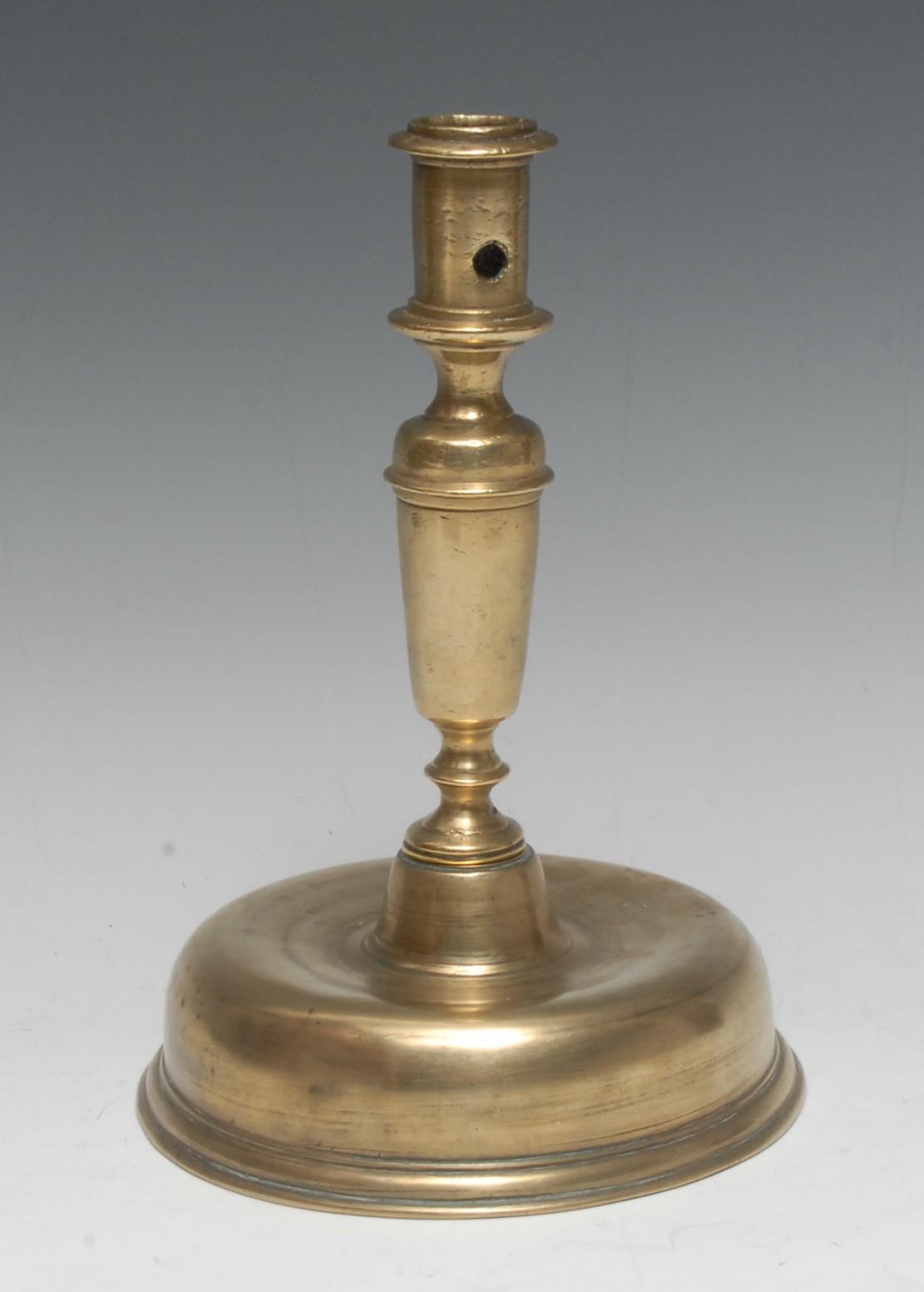 A late 17th century brass candlestick, cylindrical sconce, substantial domed base, 23cm high, c.1690