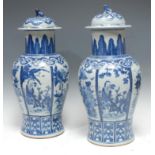 A pair of 18th century Chinese temple jars and covers, decorated in underglaze blue with alternating