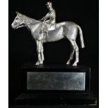 An Elizabeth II cast silver equestrian desk model, of a horse and jockey, rectangular ebonised