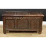 A Charles II oak three-panel blanket chest, hinged top, the front carved with strapwork, a shell