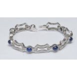 A sapphire and diamond bracelet, with alternating links of seven oval blue cabochon sapphires and