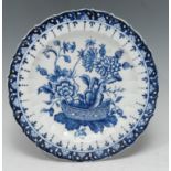 A Derby shaped circular plate, decorated in tones of underglaze blue with a basket of flowers and