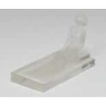A French opaque glass pin tray, moulded wioth a nude seated on the steps of a pool, rectangular