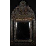 A Napoleon III shaped brown-patinated looking glass, bevelled mirror plate within a cushion frame,