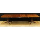 A Regency style mahogany rounded rectangular twin-pillar dining table, moulded top, turned