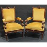 A pair of sculptural Victorian walnut armchairs, each tapered rectangular back crested by a scantily
