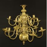 A William and Mary style brass twelve light chandelier, reel shaped sconces, dished wax pans, scroll