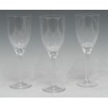 Three Lalique wine glasses, the stem with angel's head, the wings engraved to the bowl, 20.5cm high