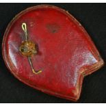 An early 20th century country house novelty desk weight, the horseshoe-shaped morocco leather base