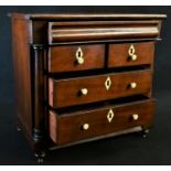 An early Victorian mahogany miniature chest of drawers, crossbanded top above a cushion moulded