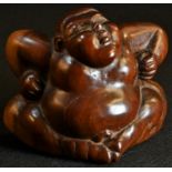 A Japanese two-tone hardwood carving, of a sumo wrestler, 8cm high, 11cm wide, Meiji period