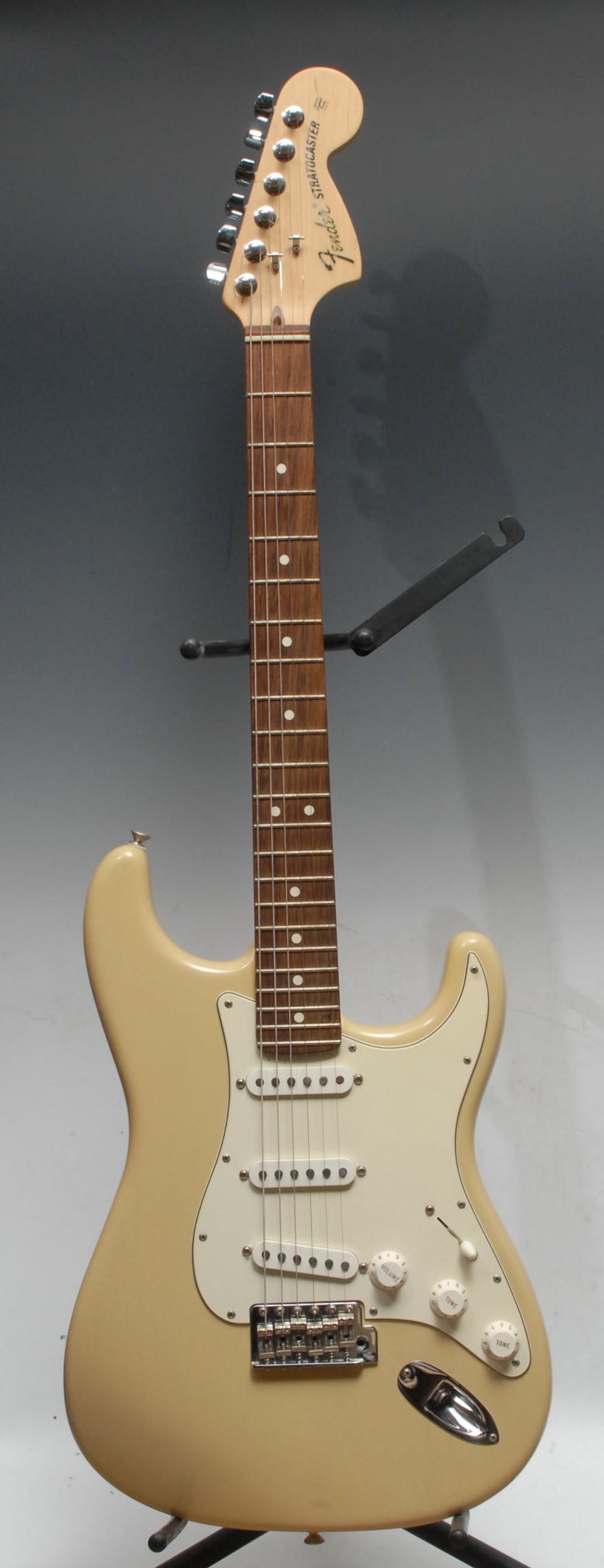 A Fender Stratocaster electric guitar, USA honey blonde, maple neck, rosewood finger board. Serial