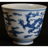 A Chinese porcelain flared tea bowl, painted in underglaze blue with ferocious dragons, concentric