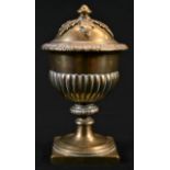 A 19th century polished bronze half-fluted urn and cover, knop finial with acanthus boss, square