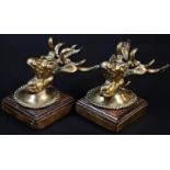 A pair of early 20th century gilt bronze country house wall plaques, as stags' heads, oak mounts,