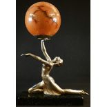 An Art Deco design silvered metal figural table lamp, as a scantily clad dancer balancing a ball,