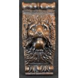 An 18th/19th century oak corbel, carved with a lion mask, 23cm long