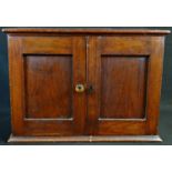 A Victorian coin collector's cabinet, oversailing top above a pair of panelled doors enclosing