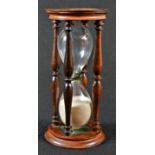A George III style turned mahogany hour glass, 16cm high
