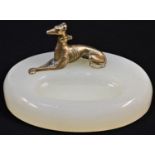 A bronze mounted desk tidy, the oval onyx base applied with a recumbent greyhound, 12.5cm wide