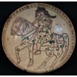 A Middle Eastern tin glazed bowl, decorated in the Persian Islamic taste with an equestrian