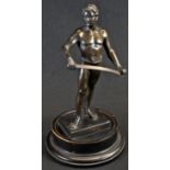 An Art Deco brown patinated library sculpture, of a warrior holding his blade, ebonised trophy