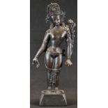 Indo-Chinese School, a dark patinated bronze, Tara, she stands, holding a ltus 'ruyi', 39cm high,