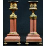 A pair of 19th century gilt bronze and rose marble candlesticks, campana sconces, reeded pillars,