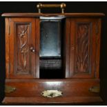 An Edwardian oak gentleman's after dinner tantalus, bail carrying handle above a cental decanter