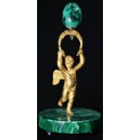A Continental gilt bronze and malachite figural pocket watch stand, as a putto, circular base,