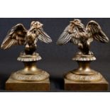 A pair of 19th century bronze desk models, each cast as an Imperial eagle, anthemion socles,