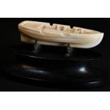 Marine Folk Art - an early 19th century whale tooth carving, of an open boat, 8.5cm long