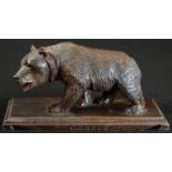 A Black Forest carving, of a bear, he stands, four square, the rectangular base inscribed '