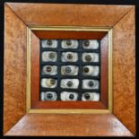 An arrangement of 19th century glass eyes, in five rows of three, 13cm x 13cm, maple frame