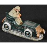 An early 20th century diecast novelty inkwell, cast as a gentleman driving a vintage motor car,