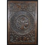 An 18th century oak panel, carved with a roundel of Classical portrait busts, back-to-back, on a