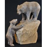 A Black Forest carving of a bear on a rock, her cub on hind legs and smiling, 19cm high, early