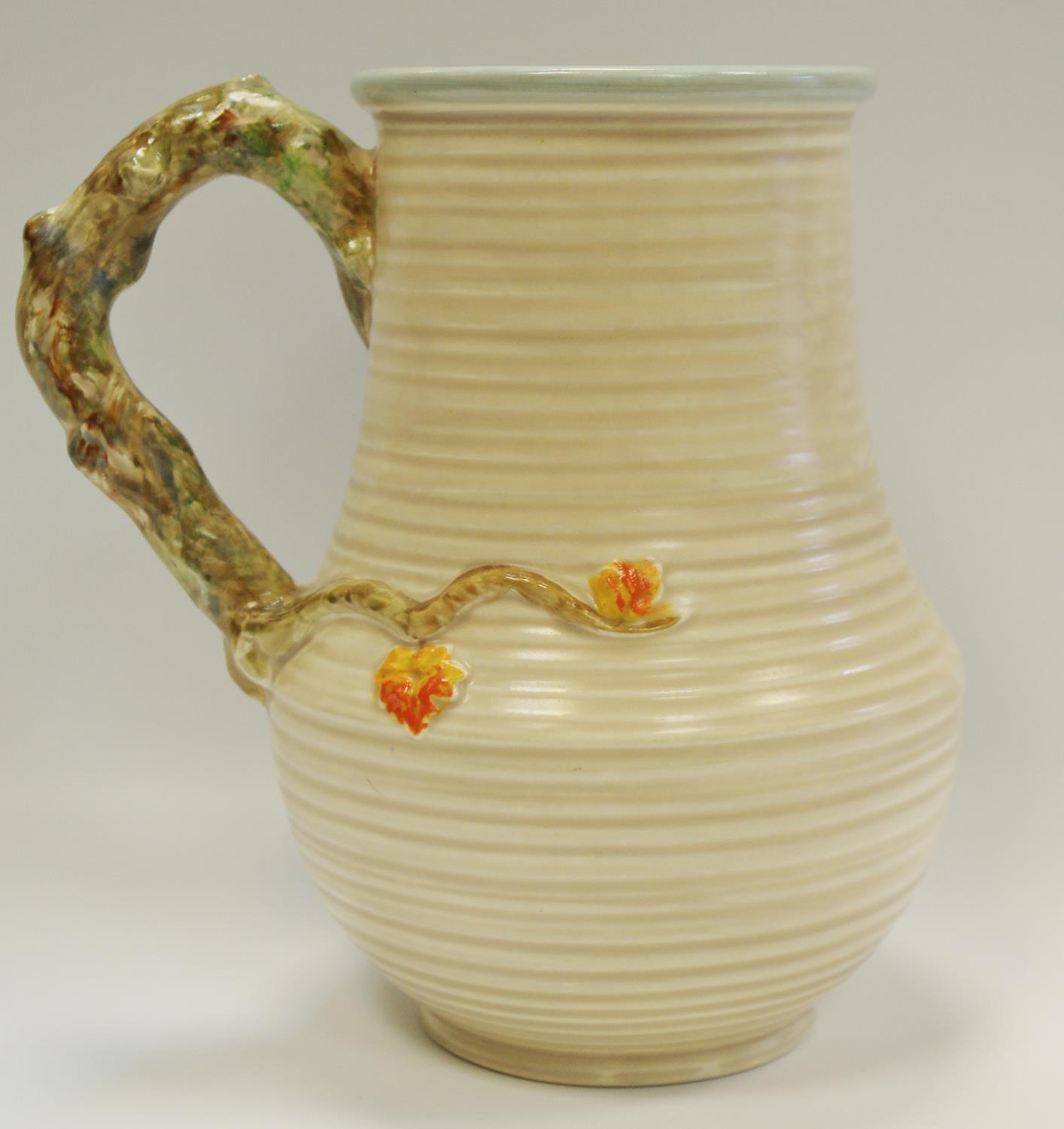 A Clarice Cliff jug moulded in relief with a parrot & foliage, naturalistic handle, ribbed - Image 2 of 2
