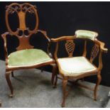 An Edwardian inlaid mahogany salon chair, open carved kidney crested back, shaped arms, cabriole