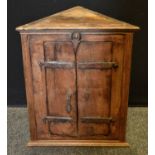 A contemporary pine 'rustic' corner cabinet, iron hinges, 53cm high