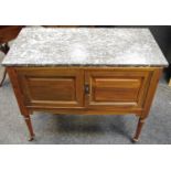 A late Victorian mahogany marble top wash stand, twin cupboard doors turned tapering legs,