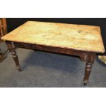 A distressed pine rounded rectangular farmhouse kitchen table, triple plank top, turned tapering