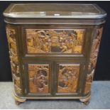 A Chinese cocktail cabinet polished hinged top, carved front and sides, opening to a fitted interior